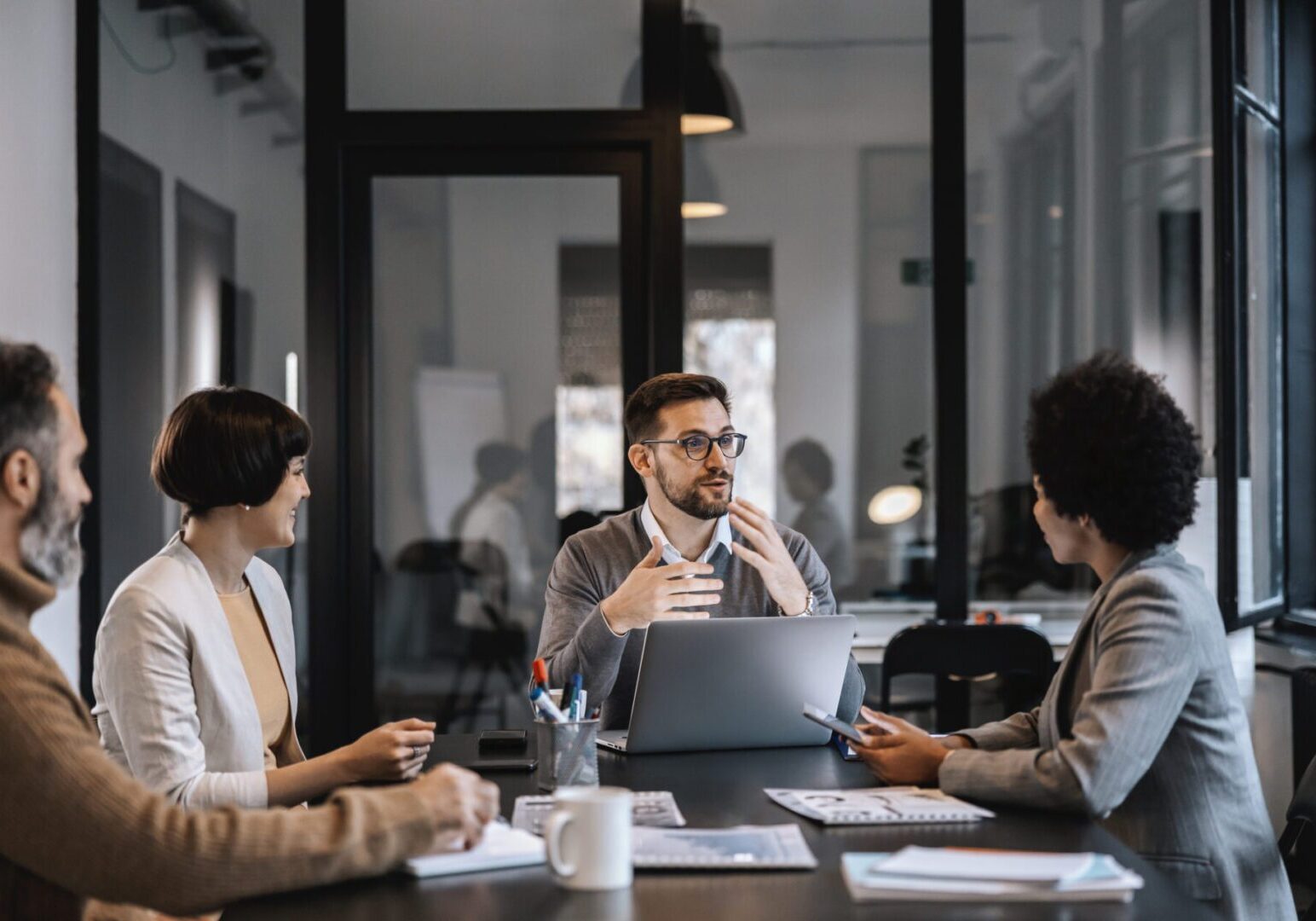 Team members discussing ideas in a modern office meeting.