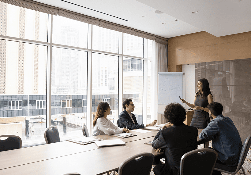 Team collaborating in a modern conference room with large windows.