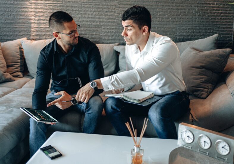 Two men discussing with a tablet.