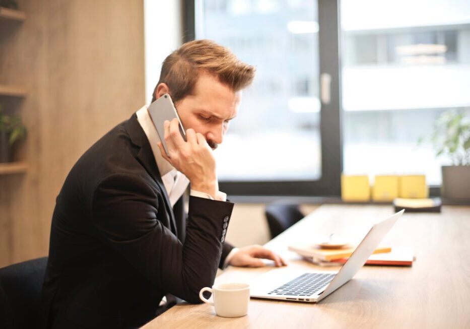 Man talking on phone at office desk.