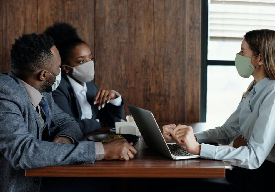 People wearing masks having a business meeting.