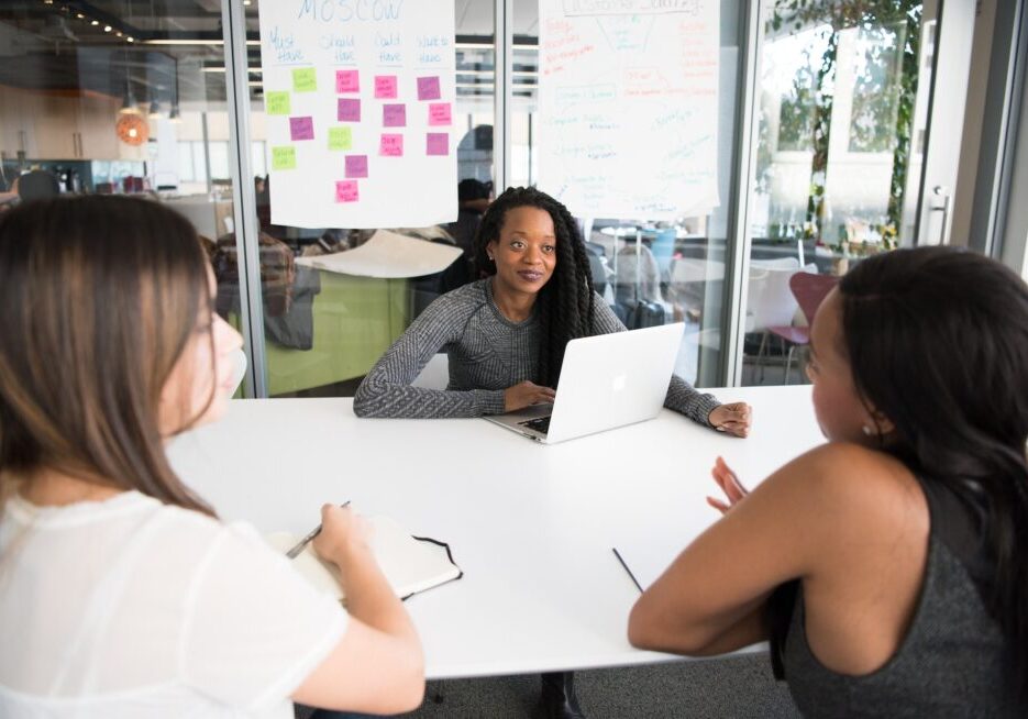 Three women having a meeting at table.