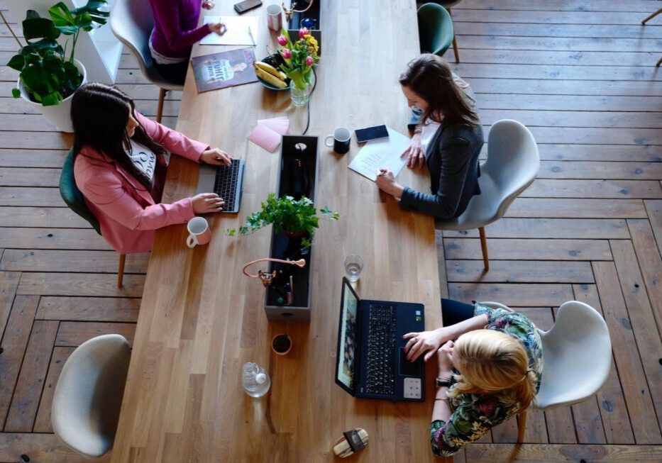People working at a large wooden table.