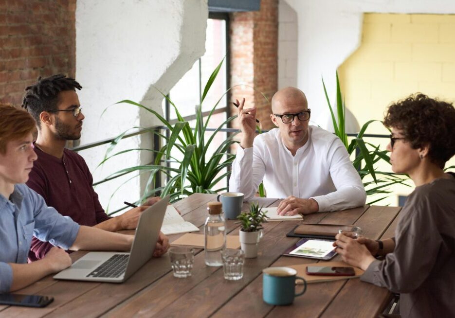 Office meeting with four people discussing.