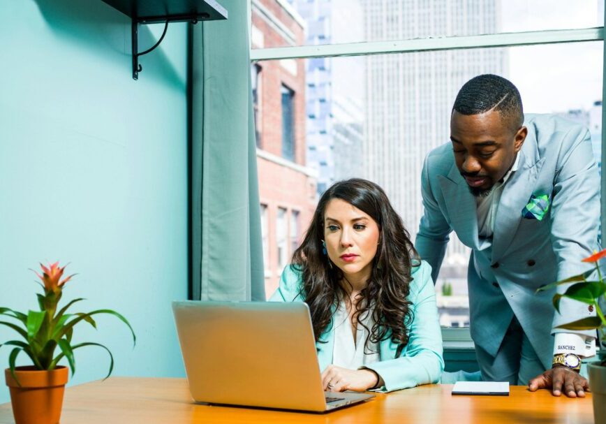 Two colleagues working together on a laptop.