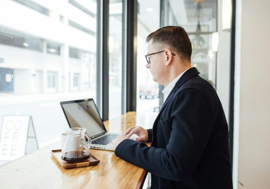 Man working on laptop in coffee shop.