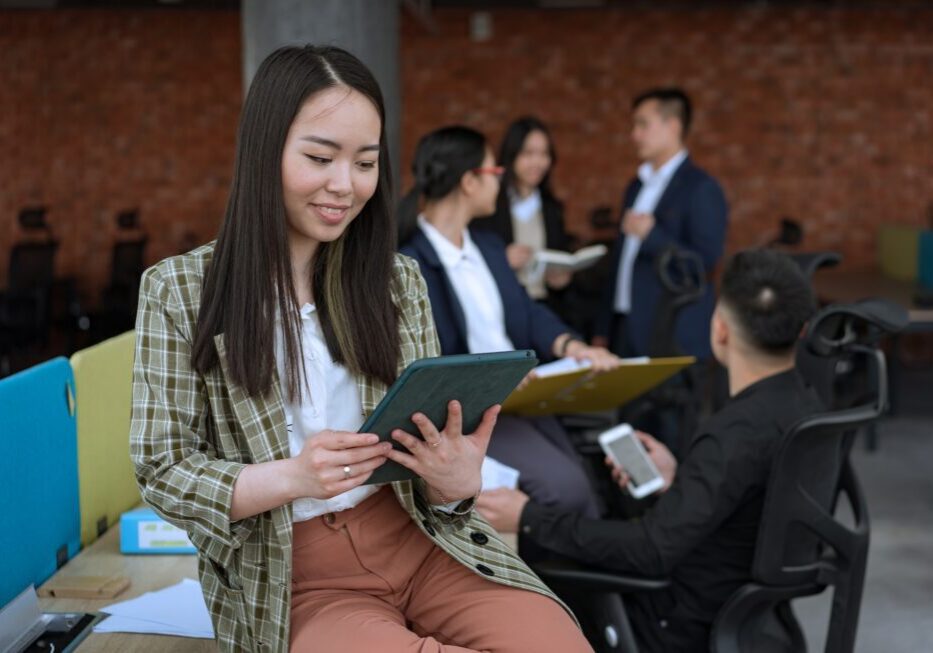 Woman using tablet in casual office setting.