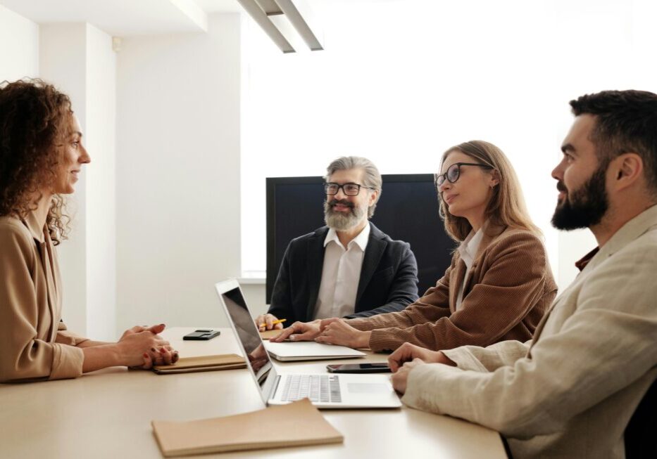 Meeting discussion with four people at table.
